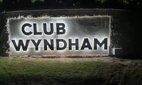 Club Wyndham illuminated letters on a stone wall at night