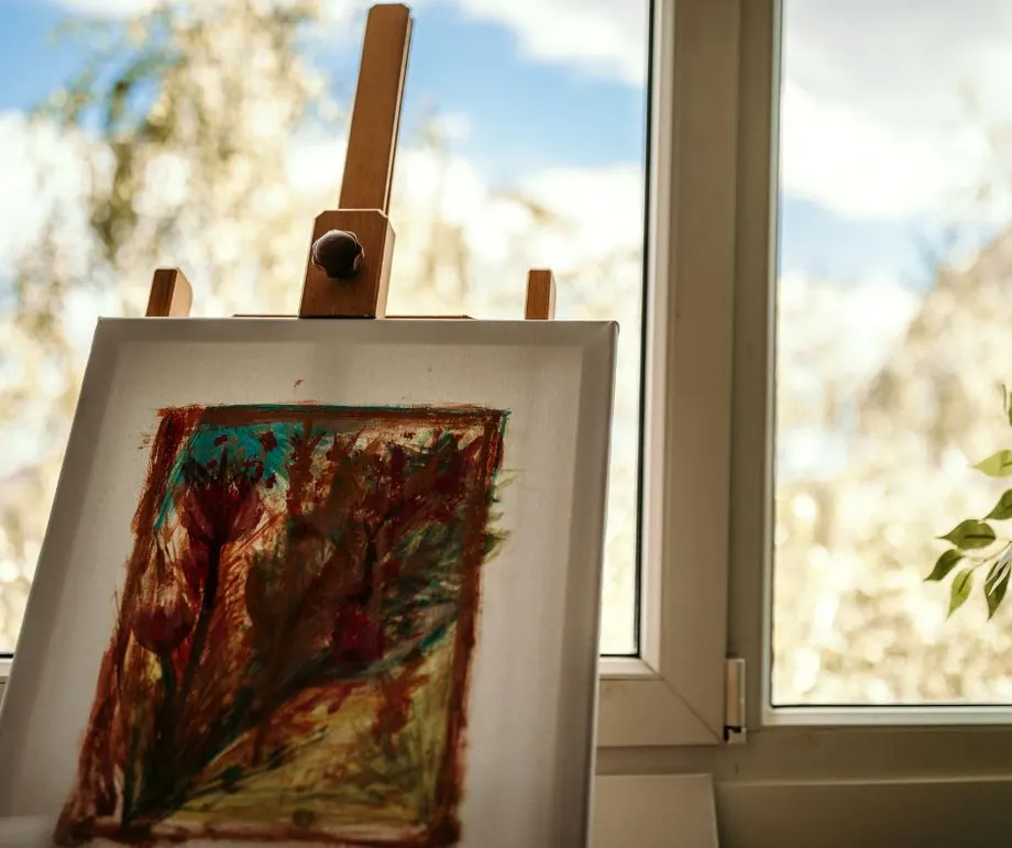 Canvas painting on an easel by a window