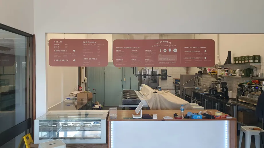 Cafe menu boards above a kitchen counter
