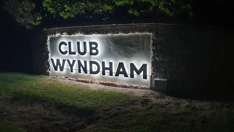 Club Wyndham backlit letters glowing on the entry wall at night