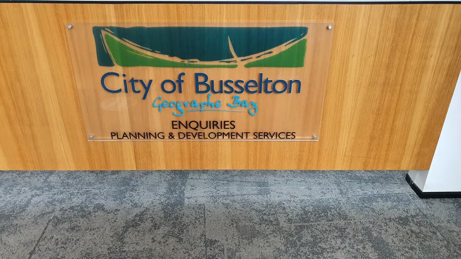 City of Busselton planning and development enquiries sign on timber panelling