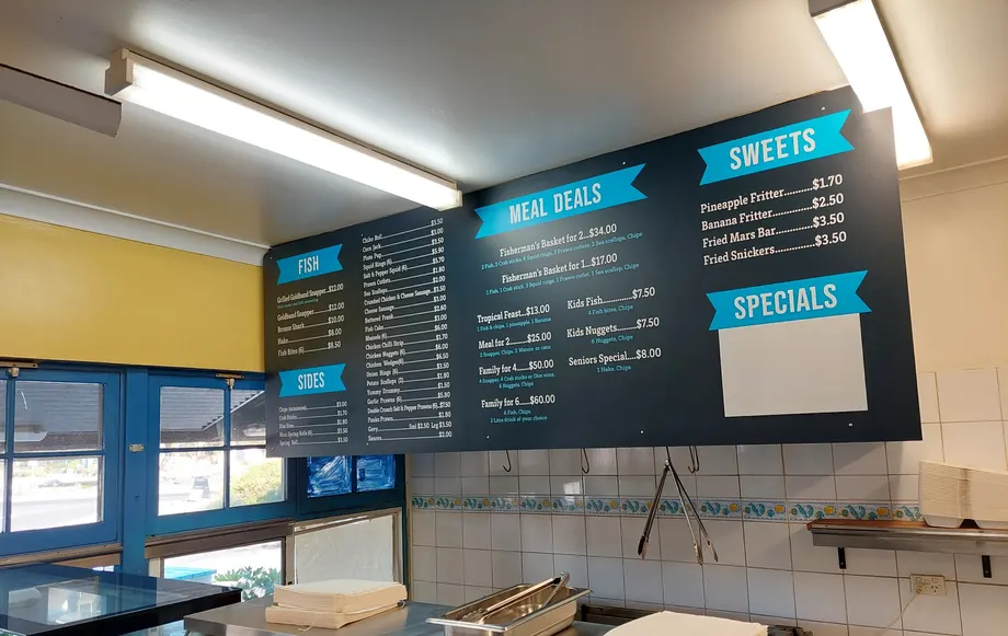 Takeaway menu boards above a shop counter