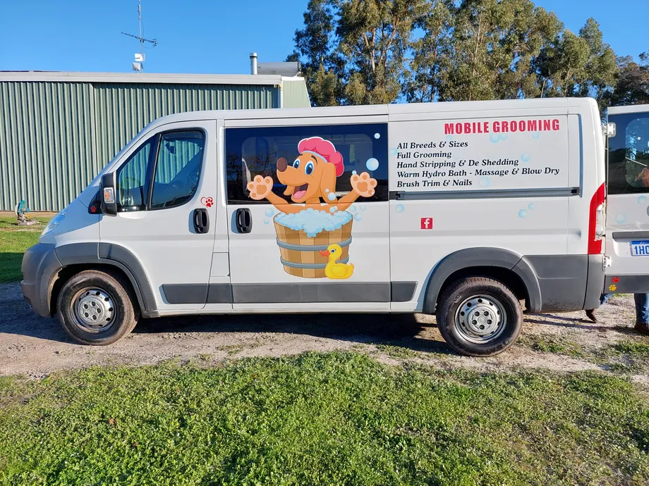 Mobile dog grooming van with cartoon graphics