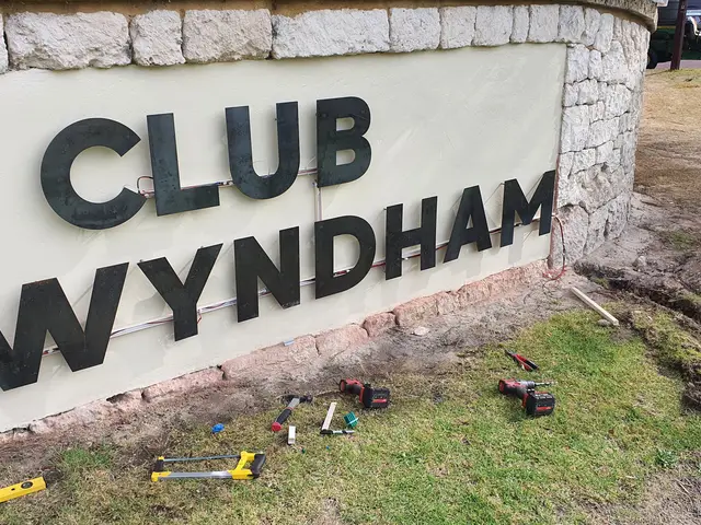 Illuminated Club Wyndham letters on a stone entry wall